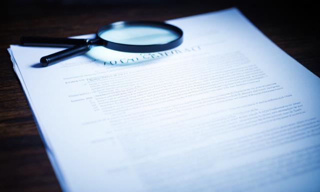 Close up of a legal document with a magnifying glass